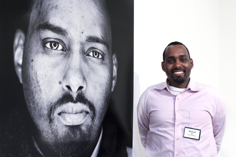 Ahmed Ali poses beside his portrait
