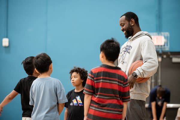 A basketball coach speaks to a group of young boys.