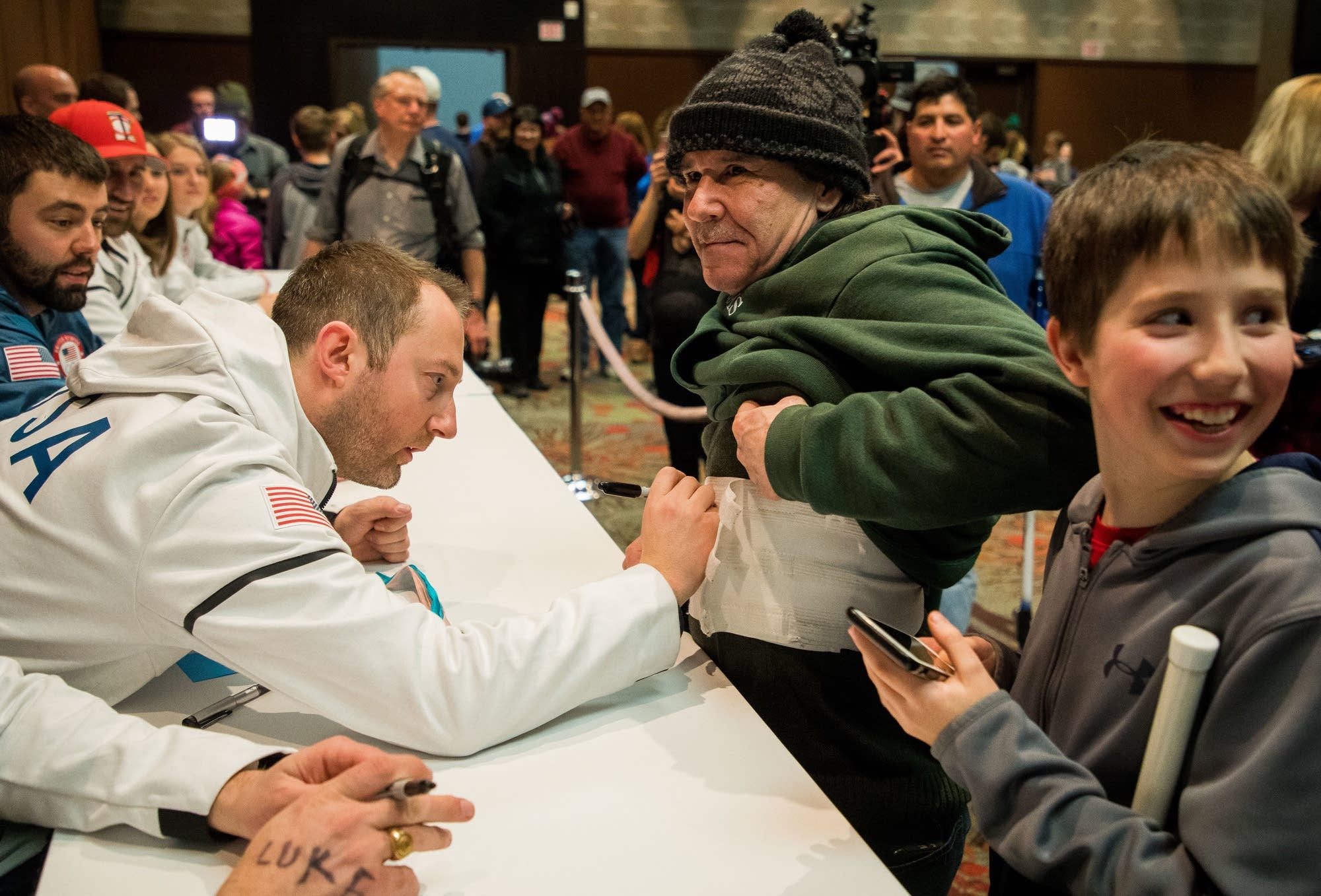 Tyler George autographs a medical wrap belonging to Philip Barnholt.