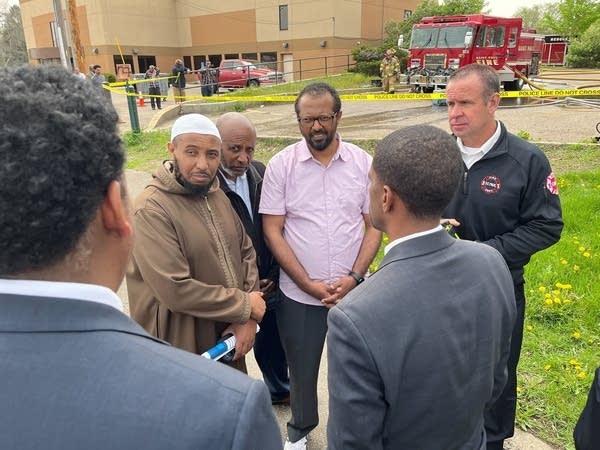 Faith leaders and a firefighter gather near the mayor.