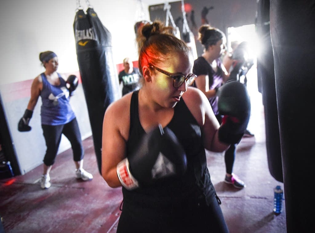 Class members punch under colored strobe lights.