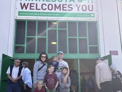 A family poses in front of a building with their kids