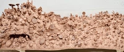 A panorama shot of a red clay sculpture with many details.
