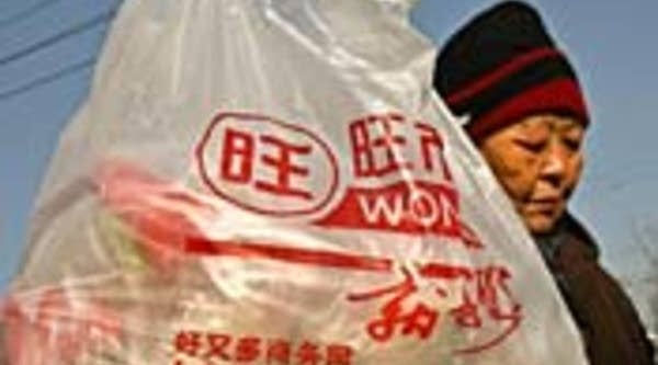 A Chinese couple stand next to their plastic shopping bag in Beijing.