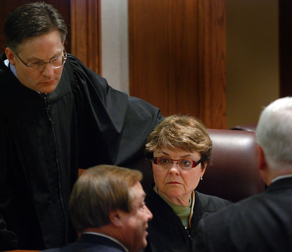 The three-judge panel listens to the attorneys