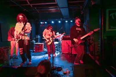 A five-piece band performing onstage in a music venue