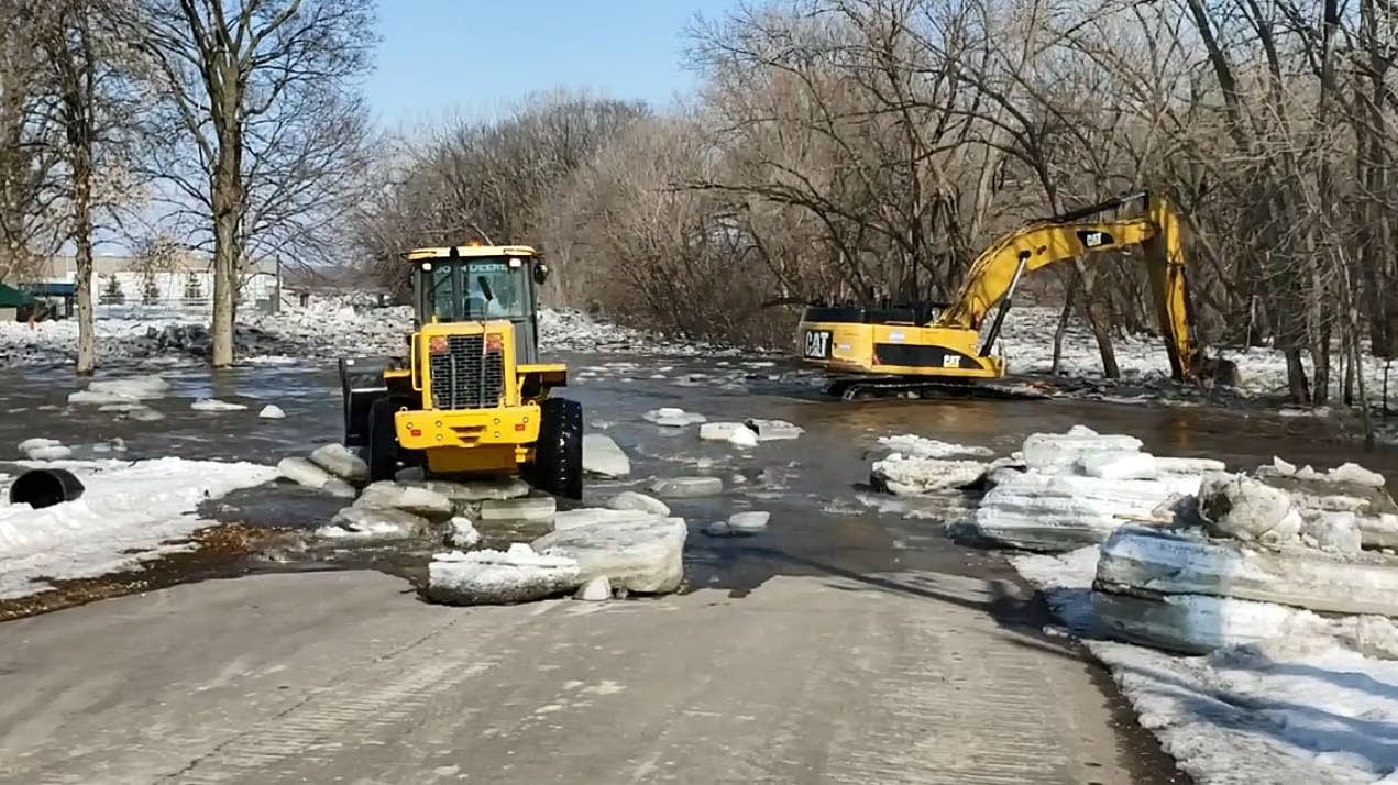Crews work to remove an ice jam in Jordan, Minn.