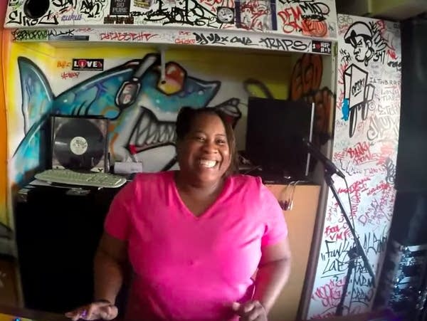 Pam the Funkstress at the tables, in a still from a 2014 video.