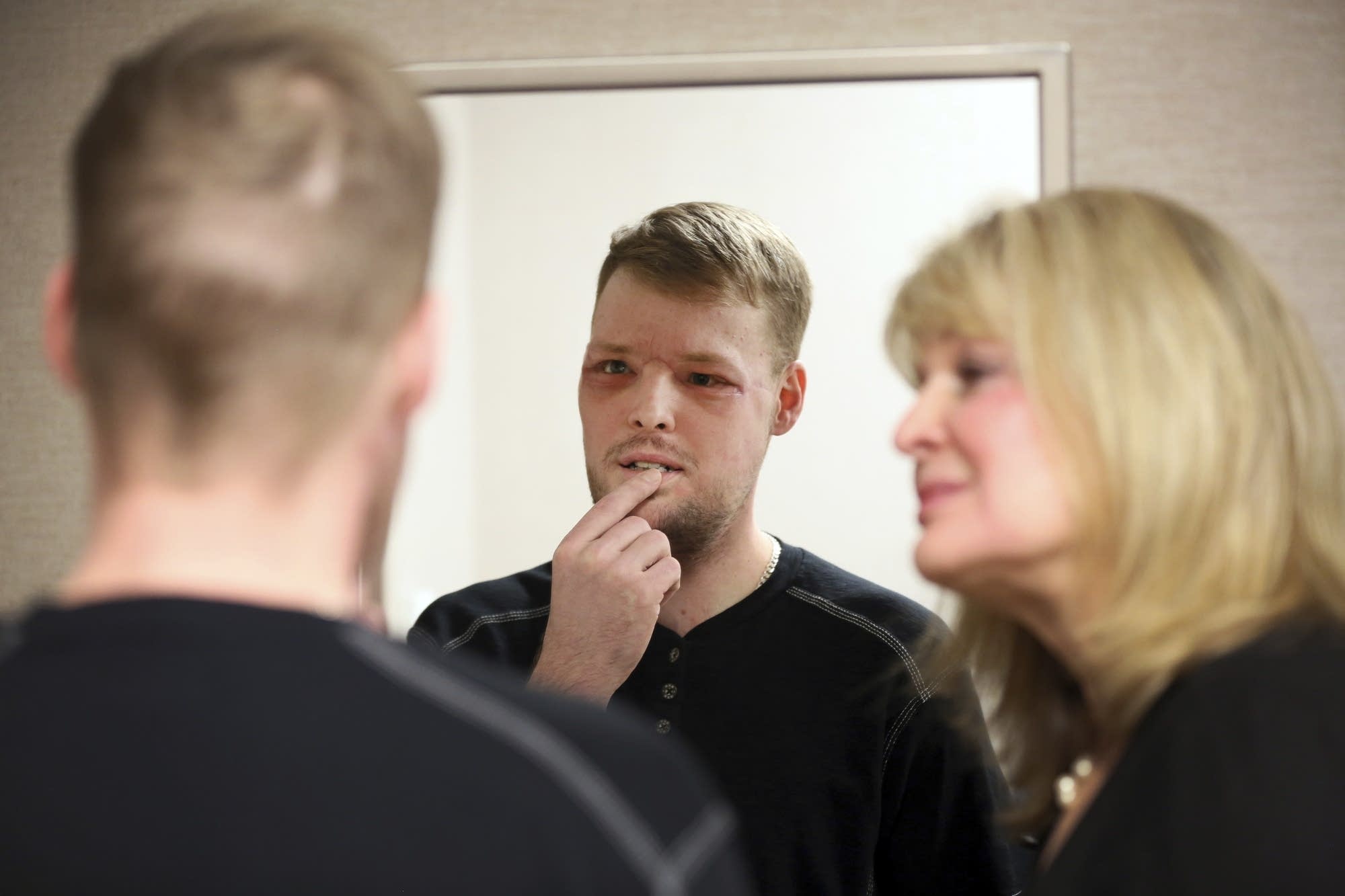 Andy Sandness looks in a mirror