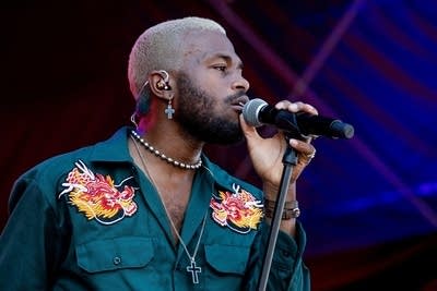 A man singing onstage at a music festival 