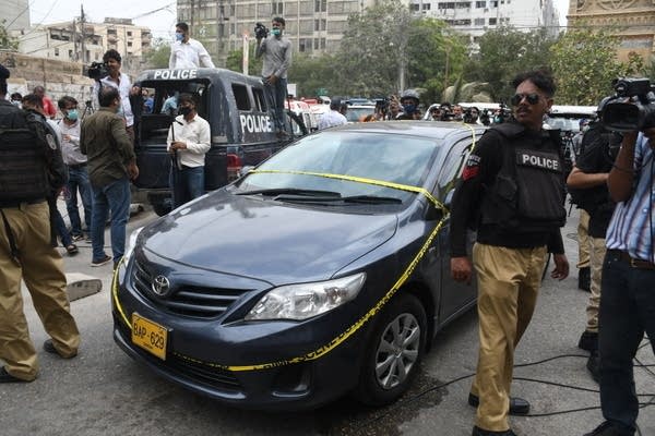 Police officers inspect the site after gunmen attacked the Pakistani stock exchange building in Karachi, Pakistan on June 29, 2020. 