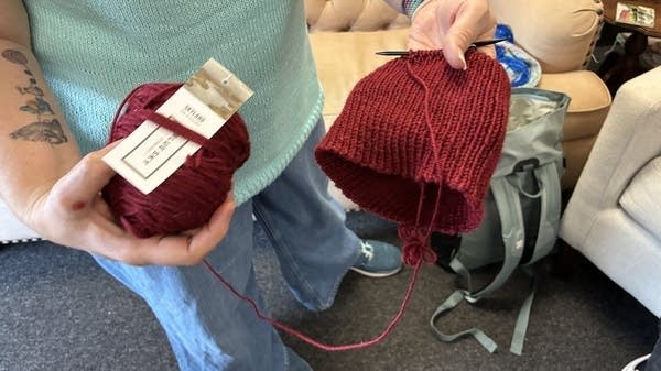 The owner of The Artful Yarn, Tiffany Perry, shows the knitting pattern of a partially made “Melt the ICE” hat. It’s gotten so popular that she’s regularly running out of red yarn in her store.