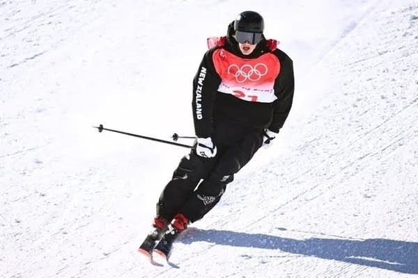 An athlete skiis down a hill.