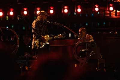 Two musicians performing together on a large outdoor stage