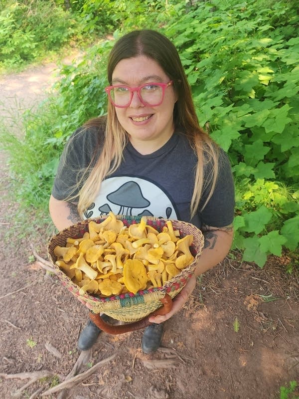 A woman holding a basket of mushrooms