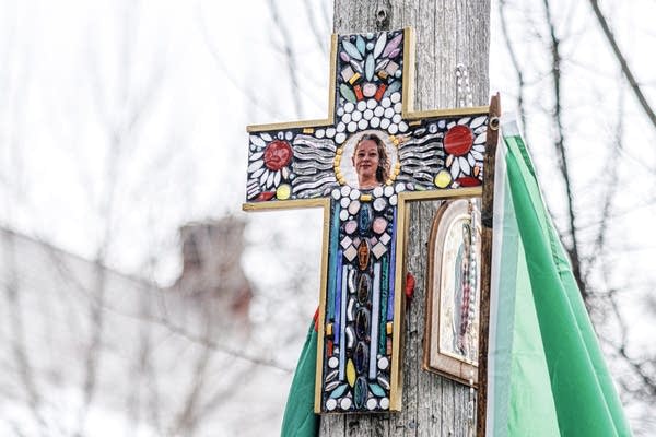 A mosaic cross bearing a photo of Renee Macklin Good