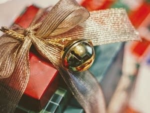 A bell decorates a wrapped present.