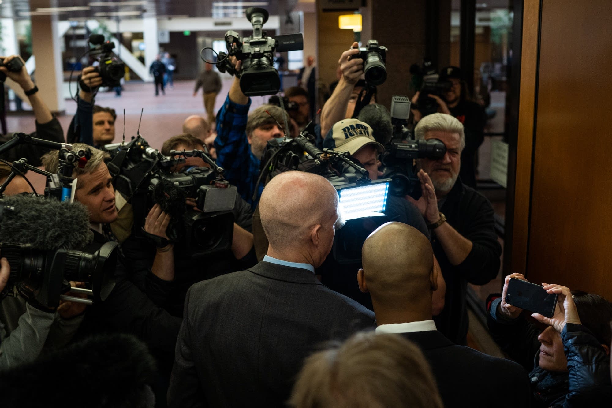 Noor and his attorneys are surrounded by media.