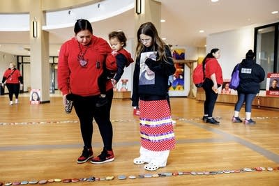 Two people standing and looking at painted stones