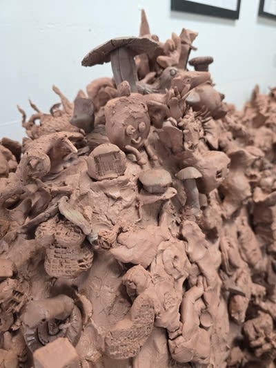 Close-up of details on a large, red clay sculpture.