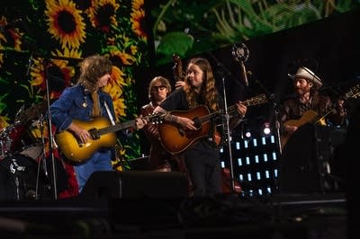 Four musicians performing together onstage