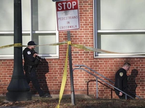 Two officers walk down stairs near a brick building