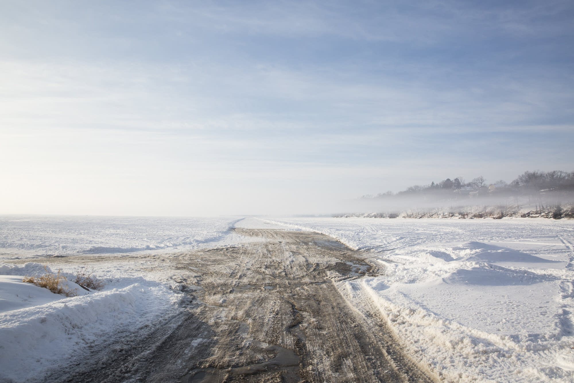 Fog floats over a plowed ice road onto Cooks Bay