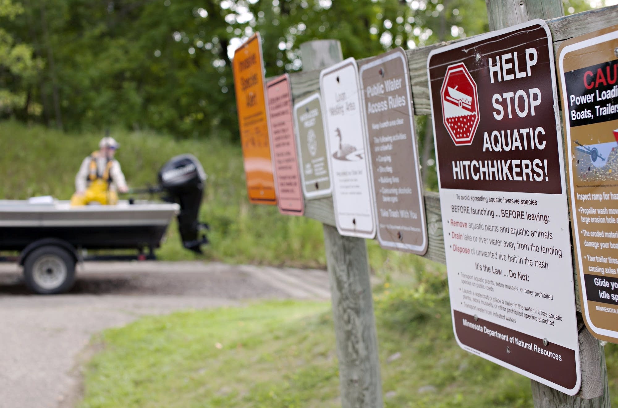 Reminders about invasive species are posted at a public boat launch.