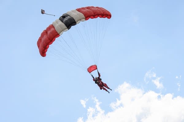 A skydiver floats beneath a parachute