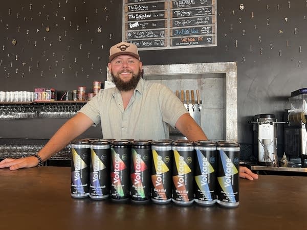 man poses with drinks