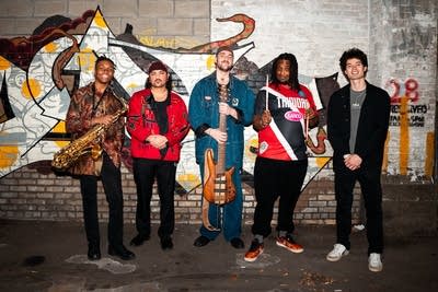 Five musicians pose backstage for a photo together