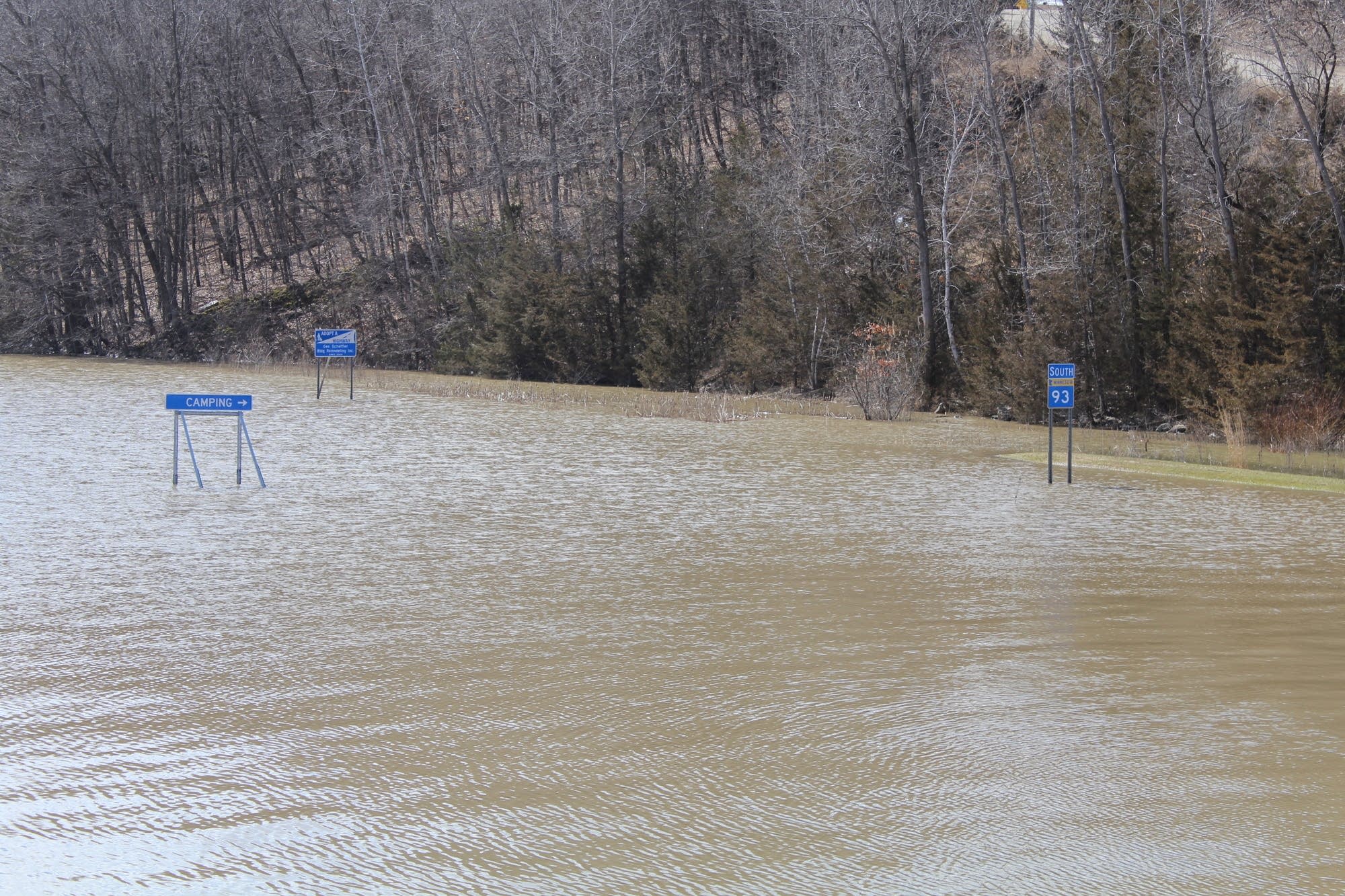 Highway signs are covered by a flooded Minnesota River