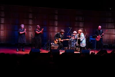 A band performing together onstage in a concert hall
