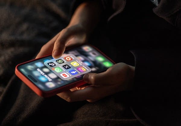 BATH, UNITED KINGDOM - DECEMBER 19: A 12-year-old boy looks at an iPhone screen showing various social media apps including TikTok, Facebook and X, on December 19, 2023 in Bath, England. The amount of time children spend on screens each day rocketed during the Covid pandemic by more than 50 per cent, the equivalent of an extra hour and twenty minutes. Researchers say that unmoderated screen time can have long-lasting effects on a child's mental and physical health. Recently TikTok announced that every account belonging to a user below age 18 have a 60-minute daily screen time limit automatically set.