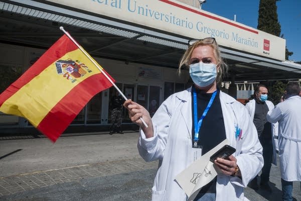Medical staff in Spain celebrate as COVID-19 infection rates slow.