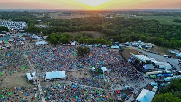 Aerial view of a music festival in a vast rural area 
