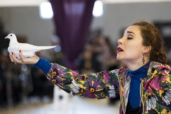 Jeanne d'Arc Casas holds a dove during a rehearsal of Garden of Names.