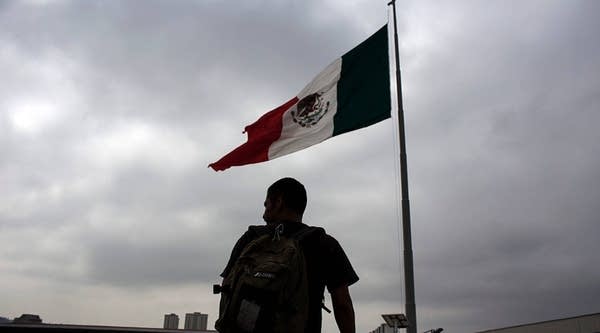 A Mexican immigrant who was deported from the U.S. is seen next to a Mexican national flag at El Chaparral repatriation center in Tijuana, northwestern Mexico on July 1, 2016.