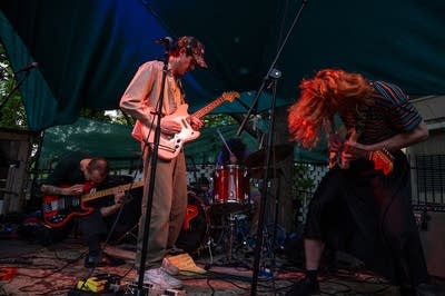 A rock band performing on an outdoor stage