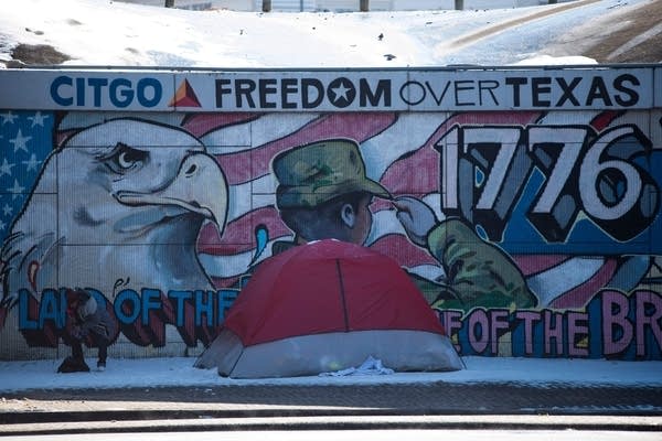 A woman moves her belongings into a tent after snow fall in Houston, Texas on February 15, 2021. 