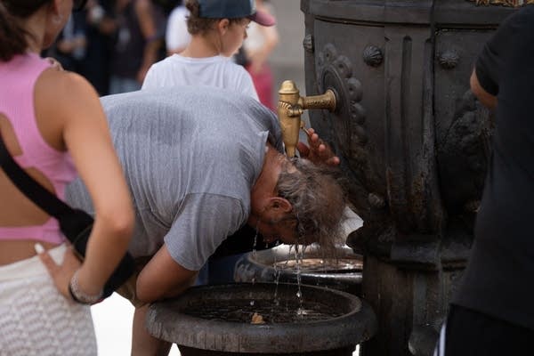 A person cools off in the Canaletas fountain in Barcelona, Spain