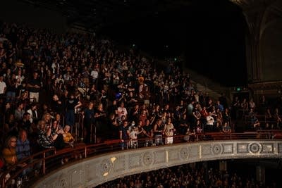 A balcony filled with music fans enjoying a concert