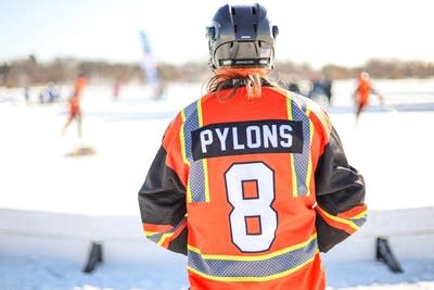 A hockey player in a hi-vis uniform is seen from behind.