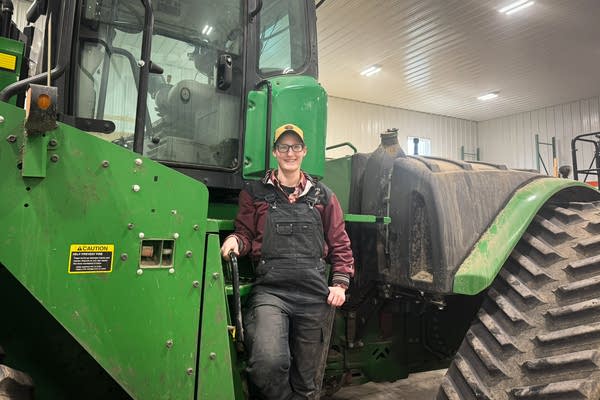 A woman posing next to tractor
