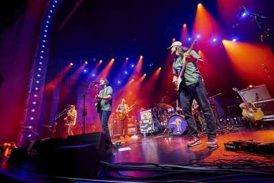 A band performing onstage in a large music venue