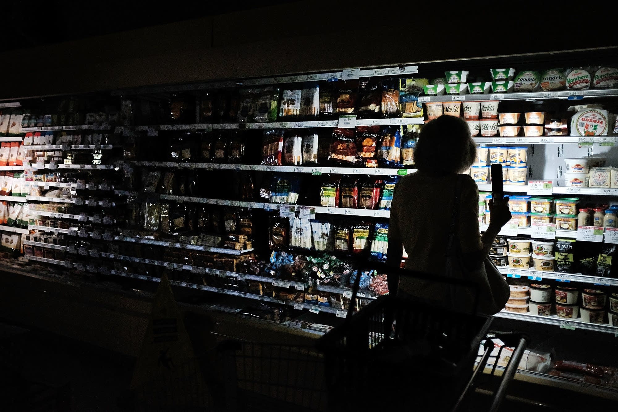 People shop in a supermarket with limited electricity.