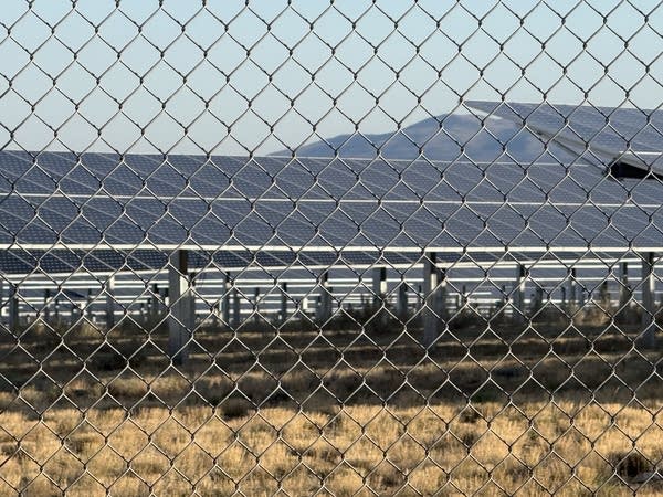 Solar panels behind a fence.