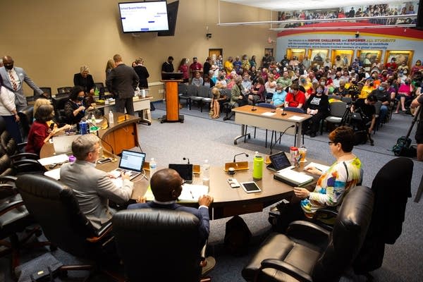 People fill a room during a meeting. 