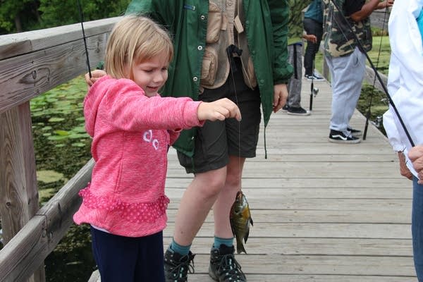 Ceci Montminy holds the fish her grandma just caught at a distance