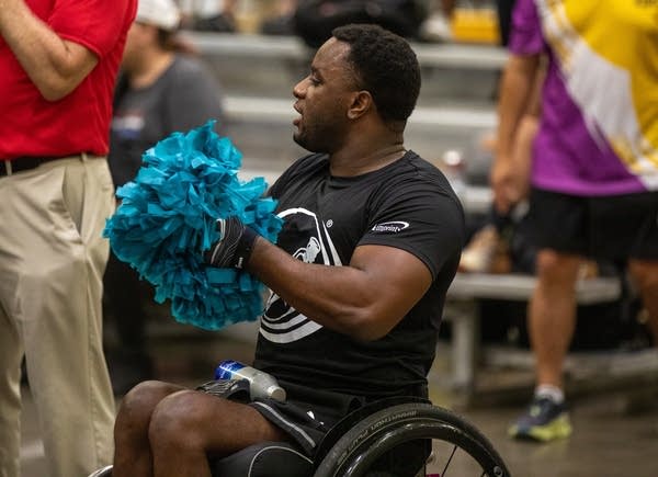 Man with blue pom poms.